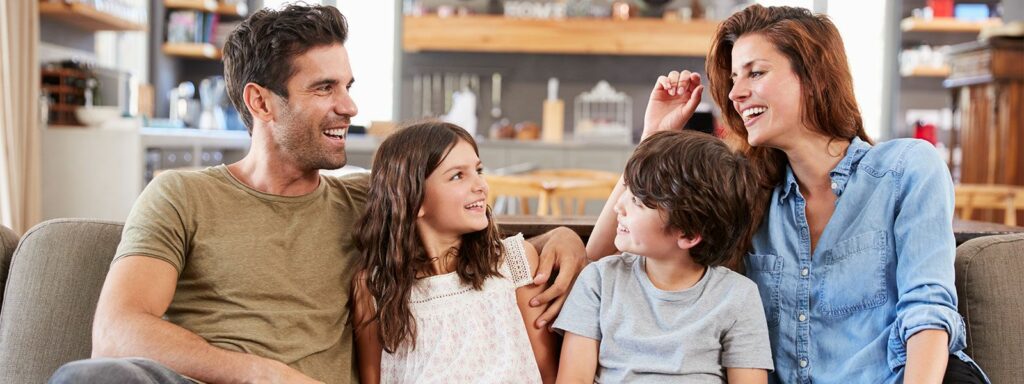 family laughing on a couch