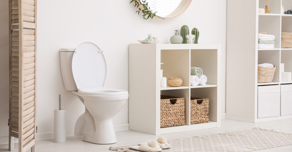 Modern toilet bowl near white wall in bathroom