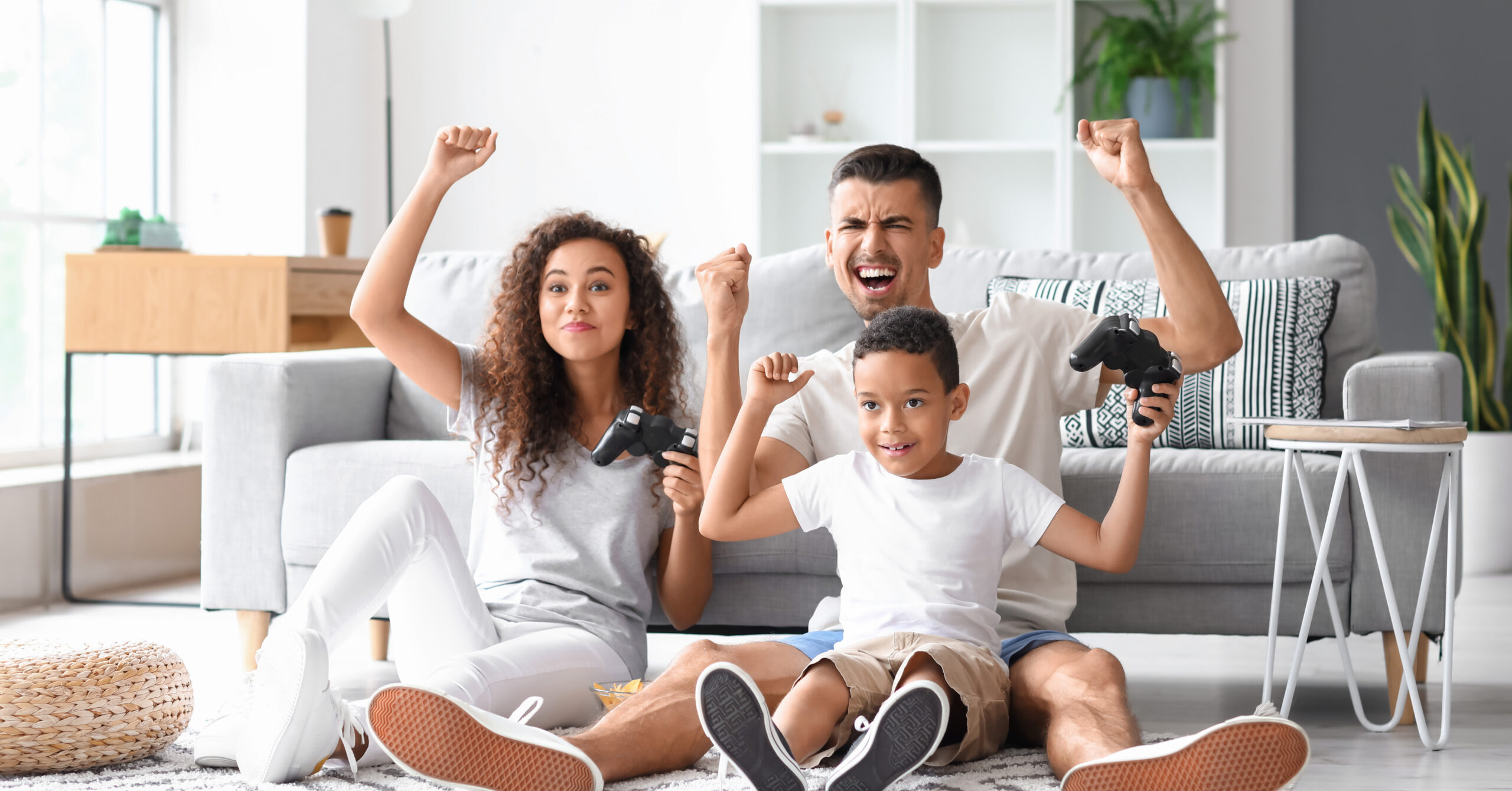 Happy interracial family playing video game at home