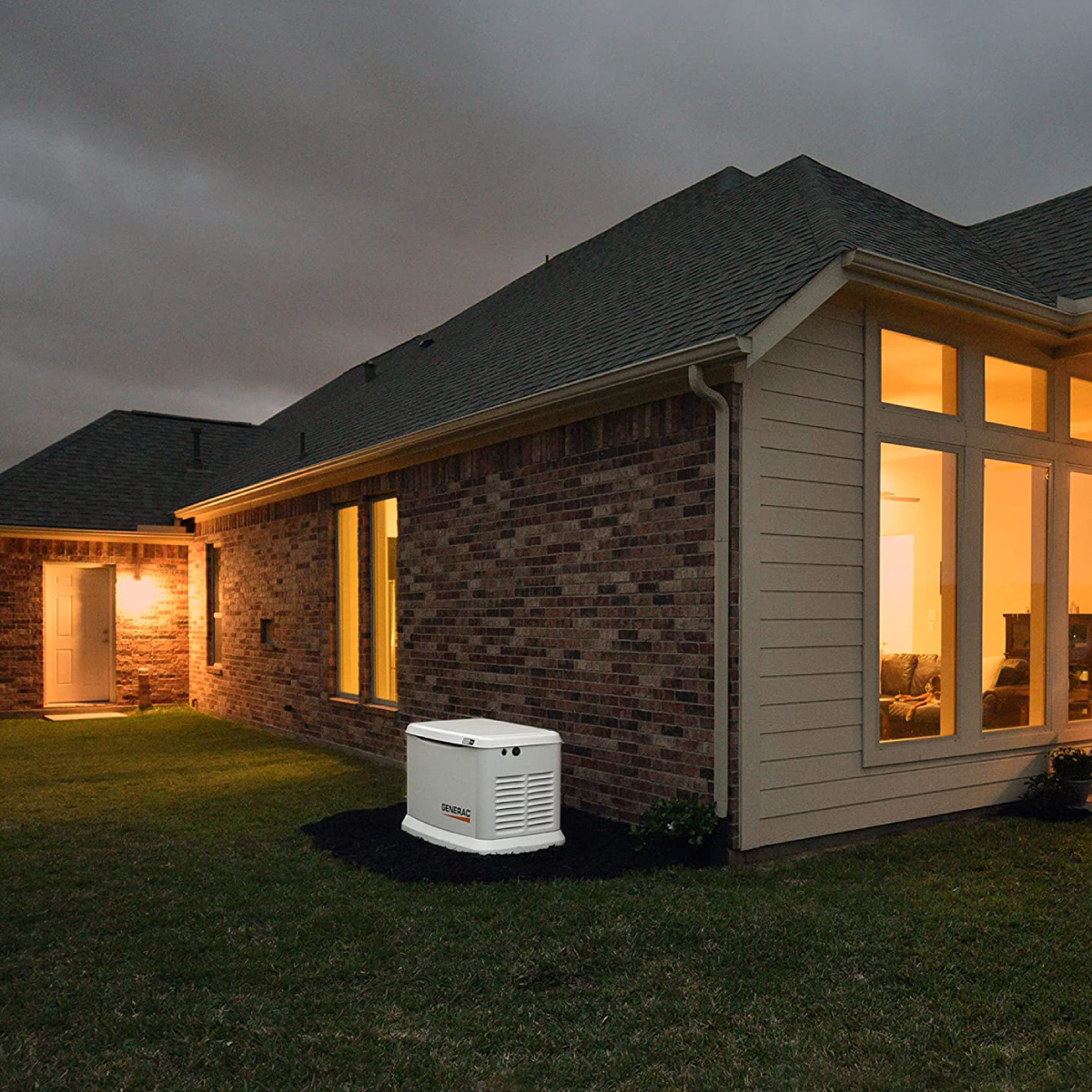 A well-lit home in the evening showing a generator installation