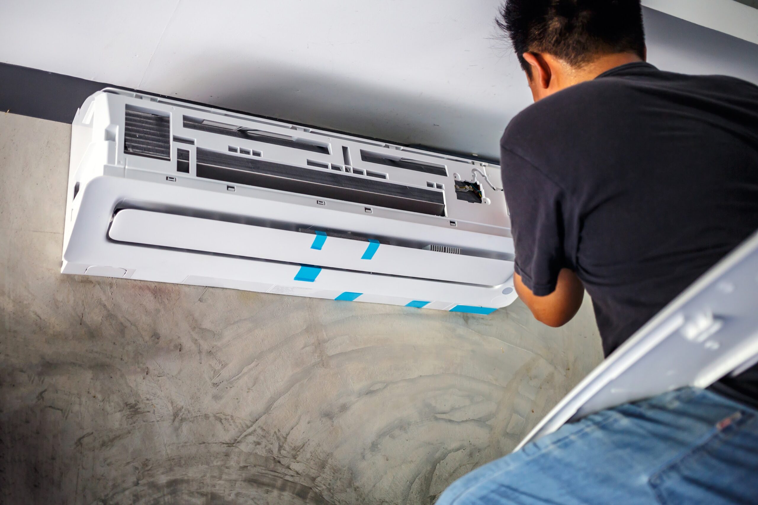 The air conditioner technician installs a new air conditioner in the room.