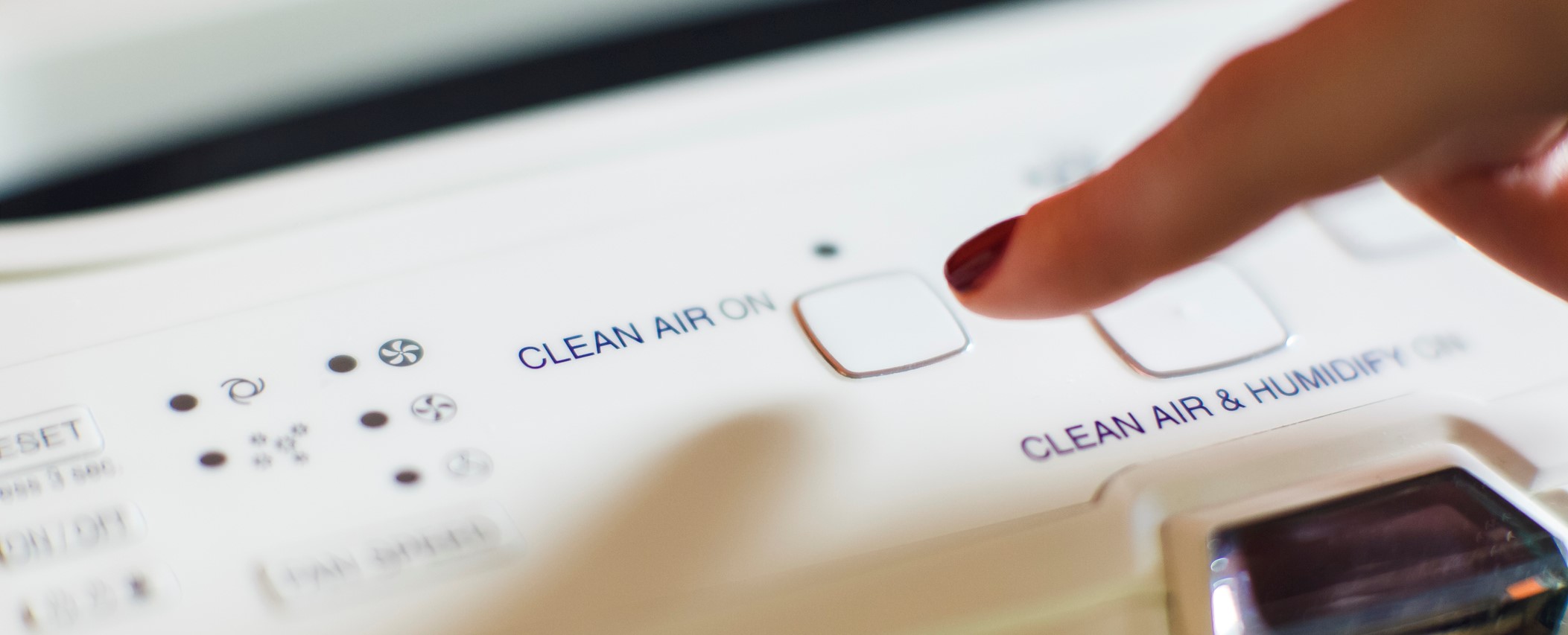 Close-up of female hand turning on an air purifier and ionizer