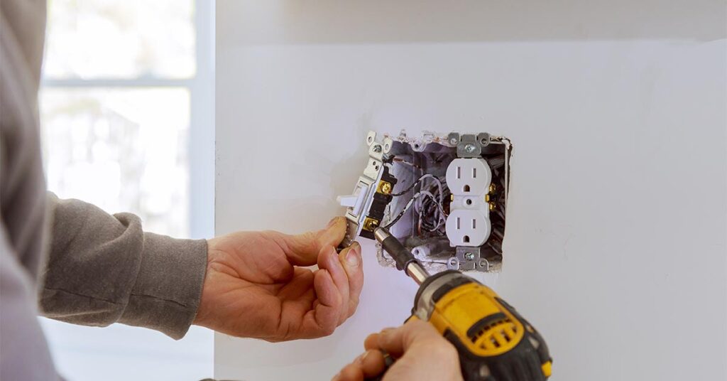 Work on installing electrical outlets with electrical wires and connector installed in plasterboard drywall