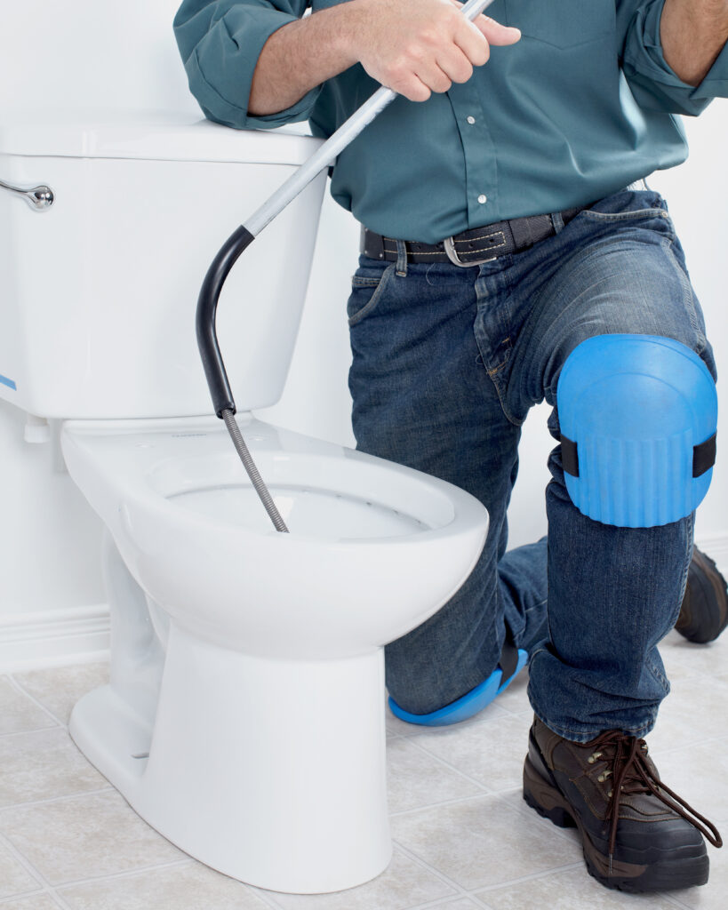 Plumber fixing a flush toilet
