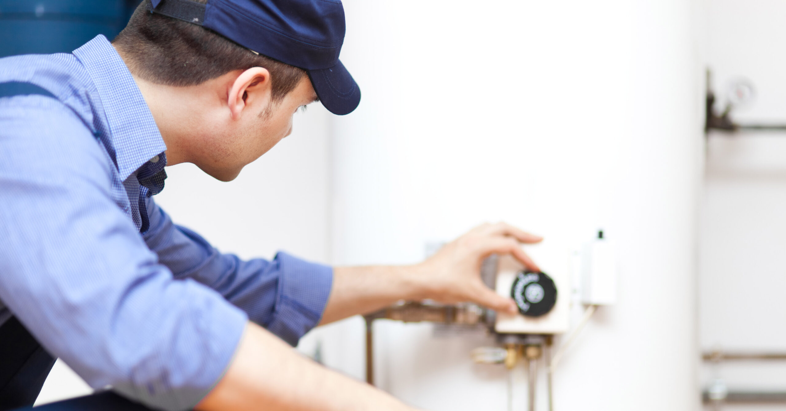 Plumber adjusting water heater