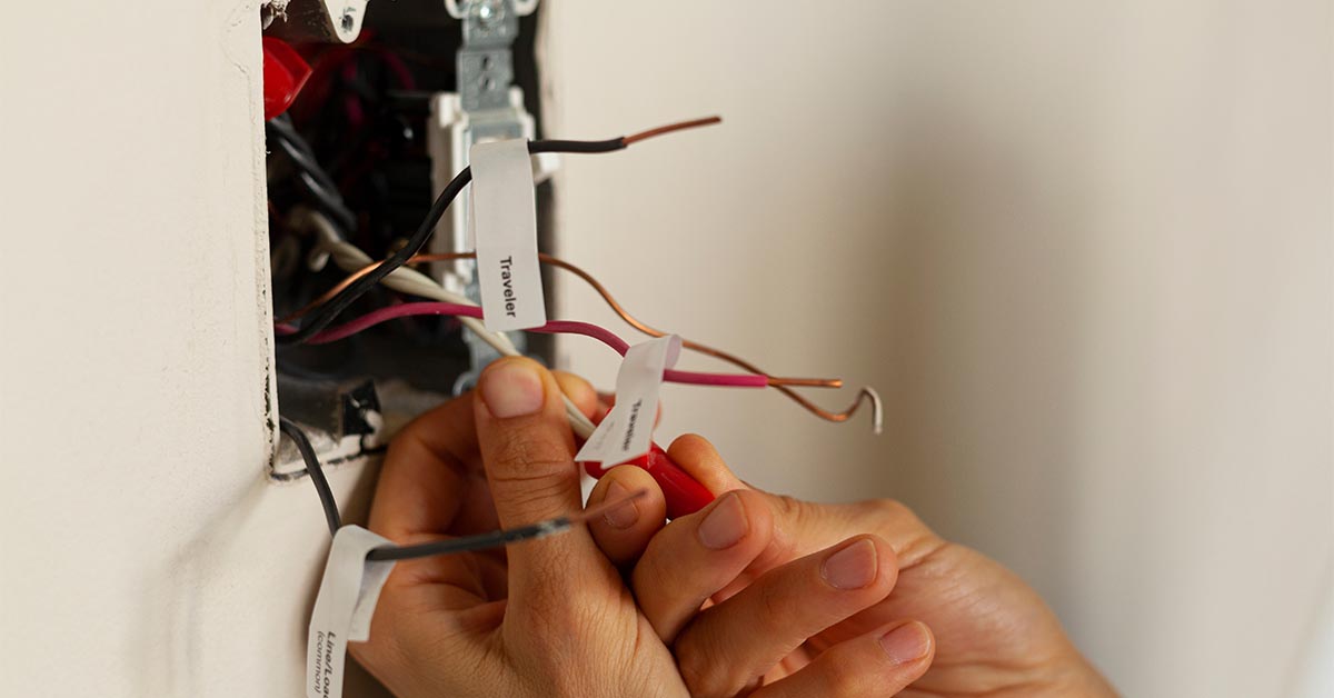 electrician rewiring a switch and an outlet