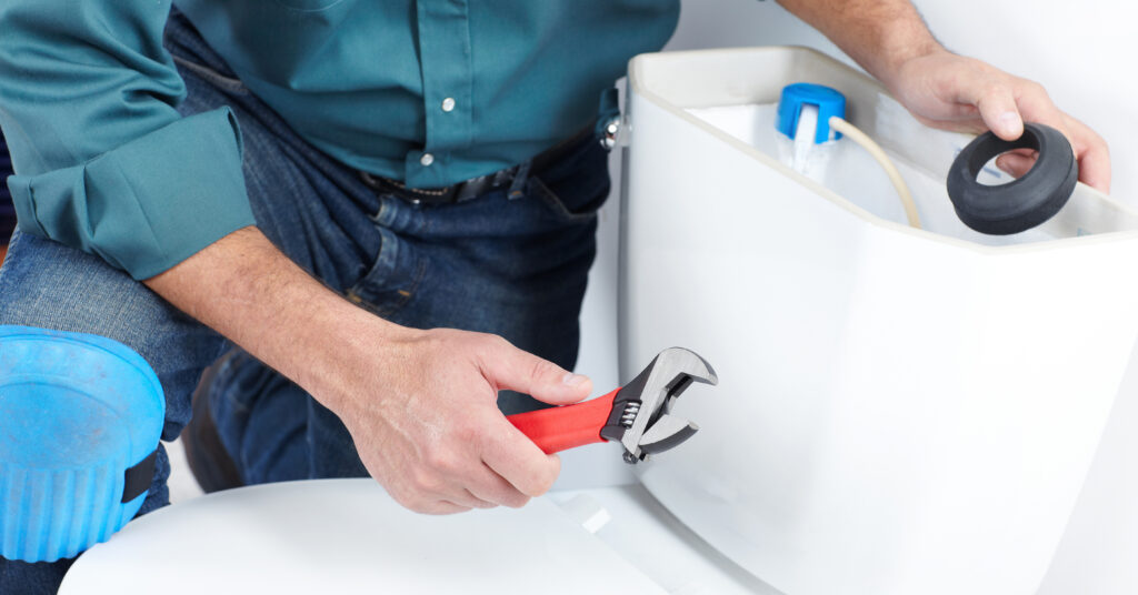 Technician repairing toilet