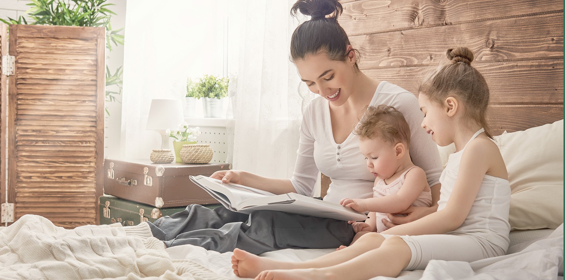 family laying on a bed reading a book