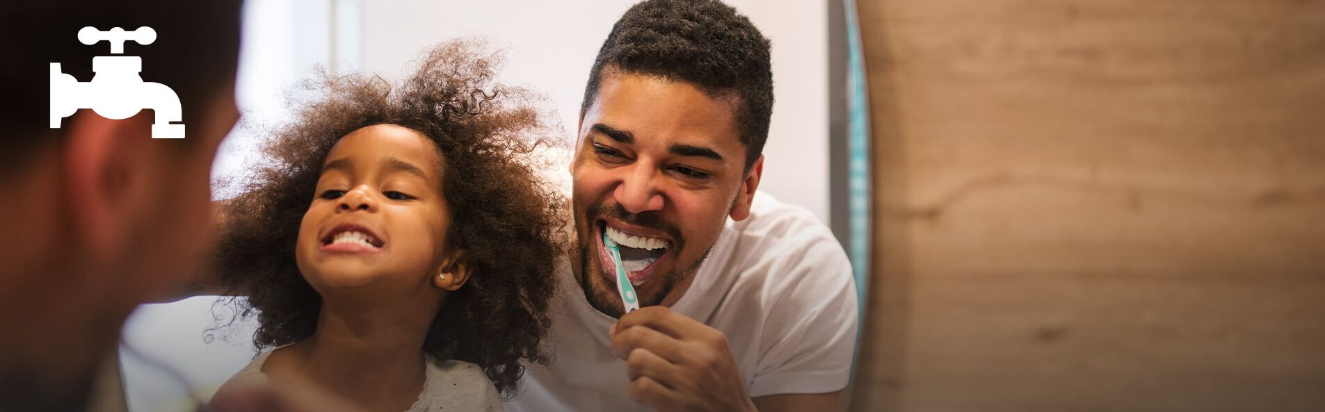 Man brushes his teeth next to child