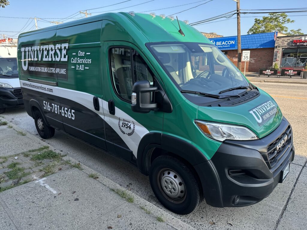 A Universe Home Services branded van is parked on the street, displaying the company’s logo, contact number, and slogan 'One Call Services It All.' The van has a green and white color scheme.