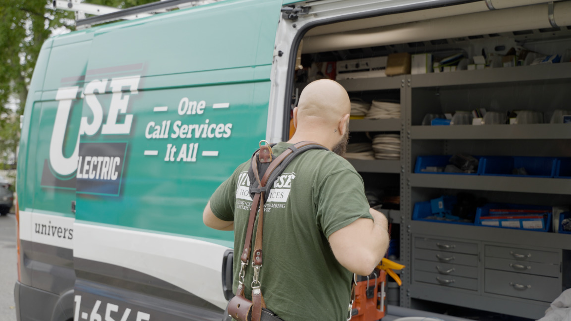 Universe Home Services Technician near open van doors